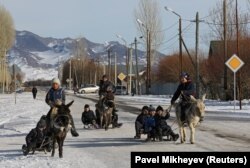 Шанасын есекке жеккен балалар қыс мезгілінің қызығын тамашалап жүр. Қарасаз ауылы, Алматы. 2021 жылғы желтоқсан.