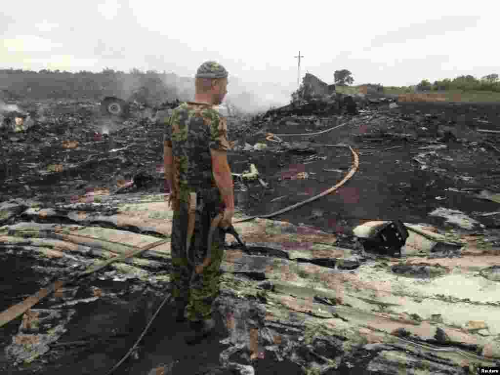 Rusiyameylli yaraqlı MH17 təyyarəsinin qalıqlarına baxır.