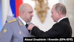 Rusiya prezidenti Vladimir Putin general Sergey Surovikinin yaxasına qəhrəman ulduzunu taxarkən (Arxiv fotosu)