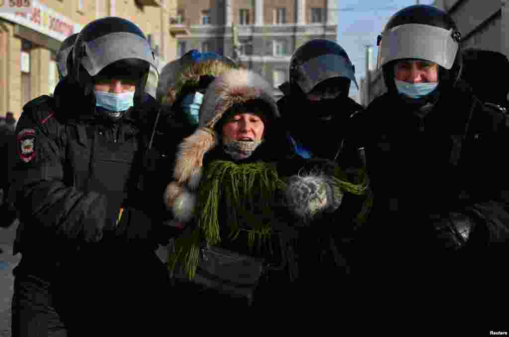 Омбыда полицейлер наразылыққа шыққан әйелді әкетіп барады.&nbsp;