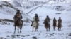 China - This photo taken on November 21, 2019 shows Chinese People's Liberation Army (PLA) soldiers riding horses as they patrol along the border of Khunjerab Pass in Kashgar in China's western Xinjiang region. (Photo by STR / AFP) / China OUT