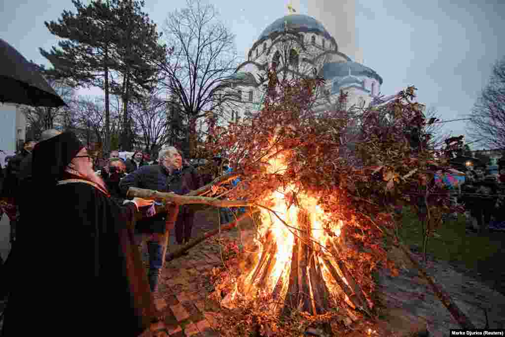 Христиане сжигают дубовые ветви перед храмом Святого Саввы в Белграде 6 января. Считается, что традиция сжигания дуба предшествовала христианству, но сейчас она является центральной частью празднования Рождества на большей части Балкан